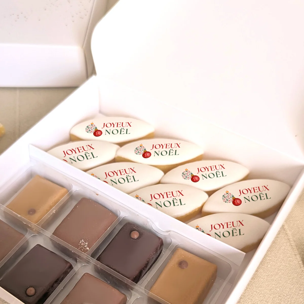Coffret gourmand de Noël avec calissons personnalisés “Joyeux Noël” et chocolats Valrhona.