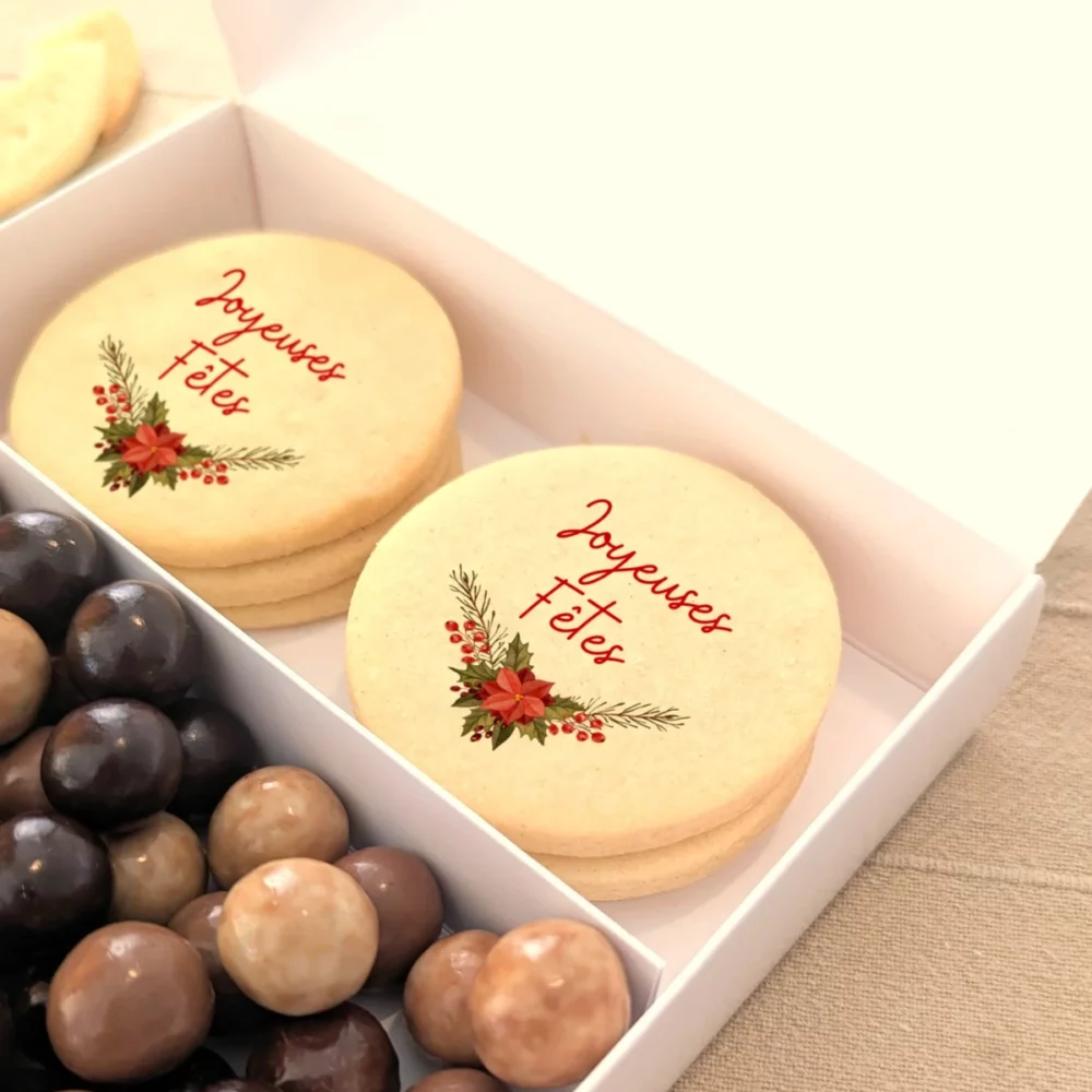 Coffret gourmand de Noël avec deux biscuits “Joyeux Noël” et perles de chocolats.