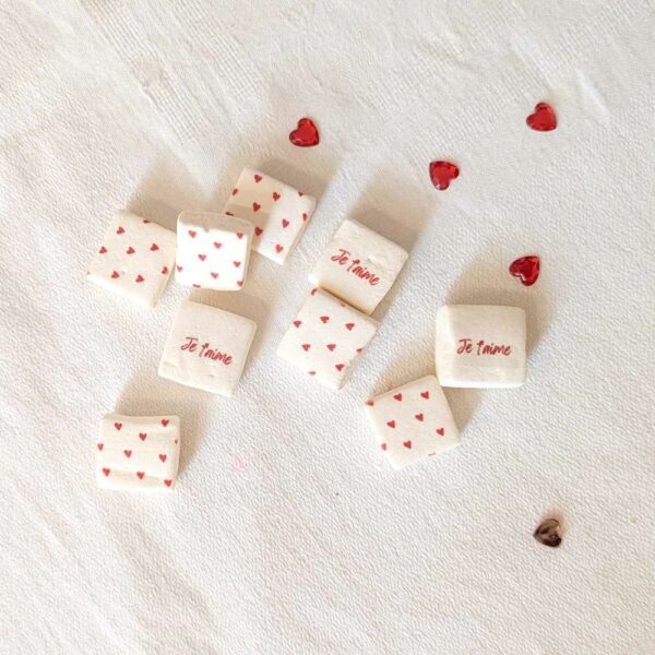 Sachet de 40 mini guimauves cœur avec inscription "Je t'aime", ruban rouge et étiquette personnalisable.