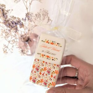 Duo de guimauves personnalisées mariage floral avec motif fleurs orangées et prénoms des mariés.