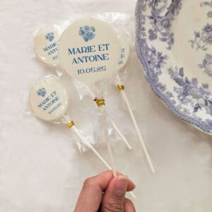 Sucettes personnalisées mariage Chic, décorées d’un motif toile de Jouy bleu et des prénoms des mariés.